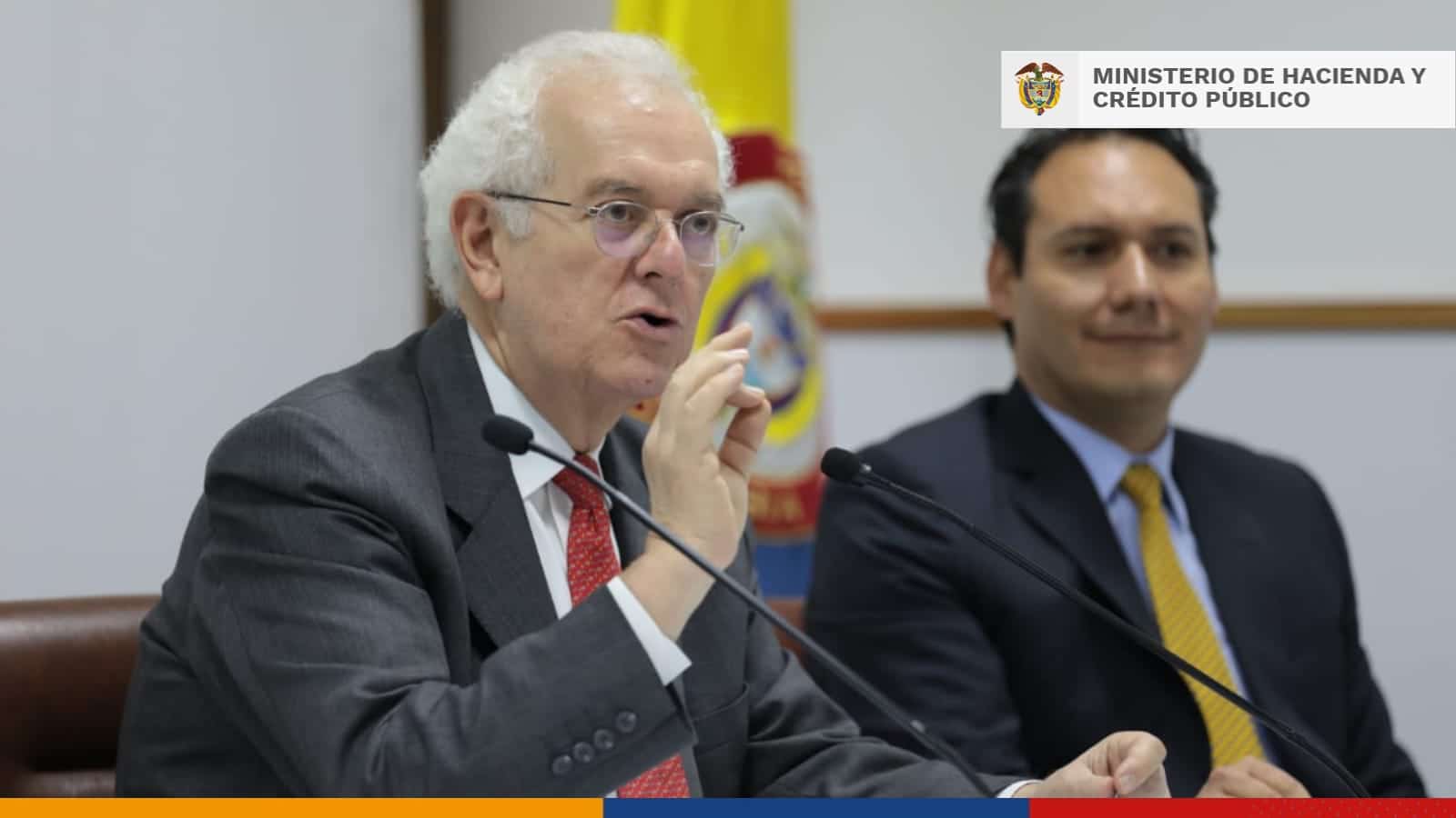 ministro de haciendo habla y gesticula con sus manos en una mesa de di&aacute;logo