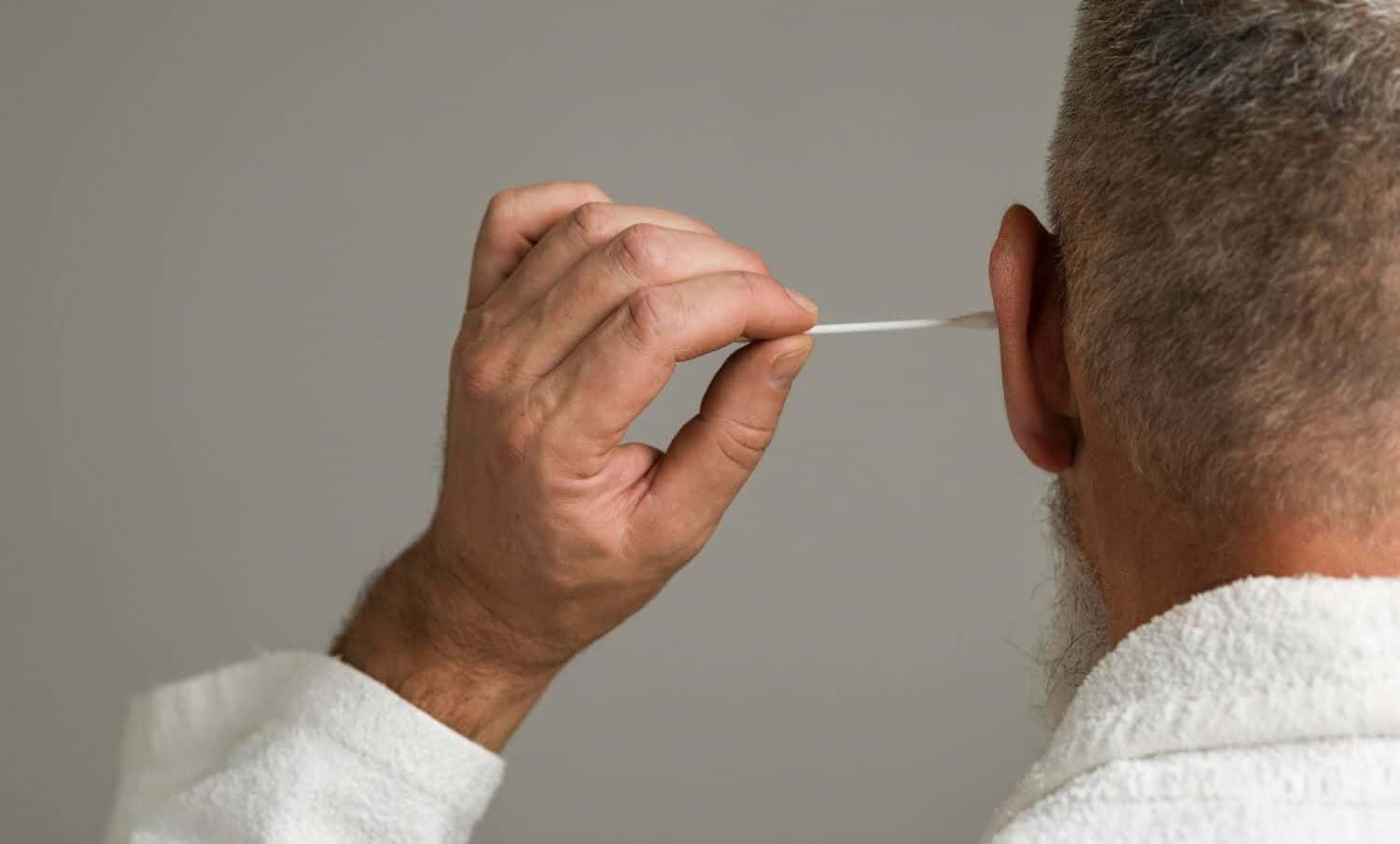 Hombre de cerca con hisopo de algod&oacute;n / Limpiar los o&iacute;dos con hisopos