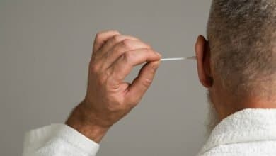 Hombre de cerca con hisopo de algod&oacute;n / Limpiar los o&iacute;dos con hisopos