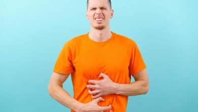 hombre con gesto de malestar, se agarra su est&oacute;mago por dolor, a causa de gases abdominales