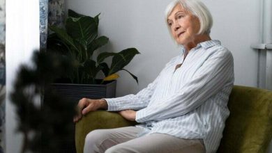 persona de la tercera edad sentada y mirando por la ventana / demencia