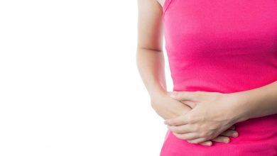 joven vestida con una camisa rosa sufre de dolor abdominal / apendicitis