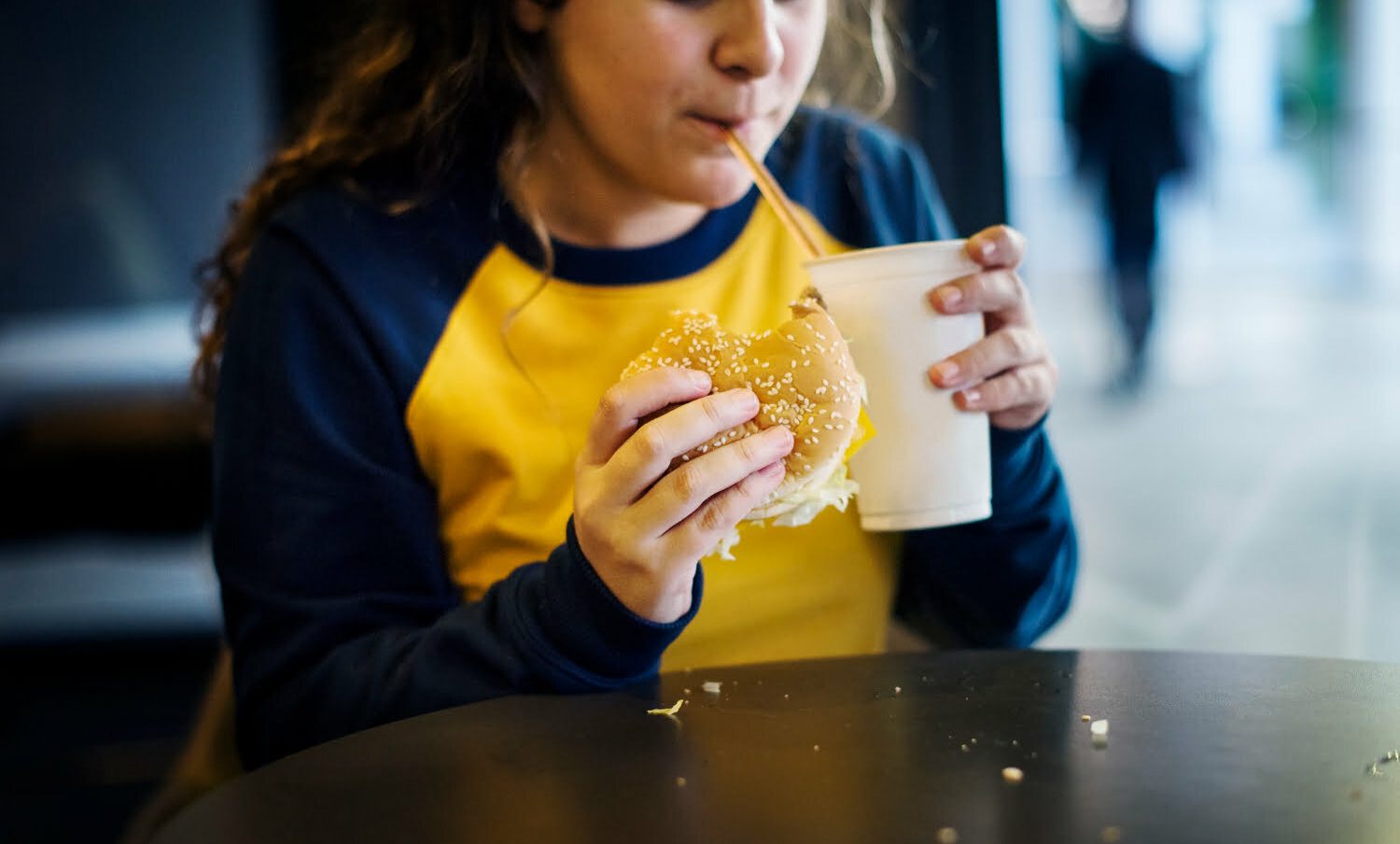 niña comiendo hamburguesa y gaseosa - sobrepeso en los niños