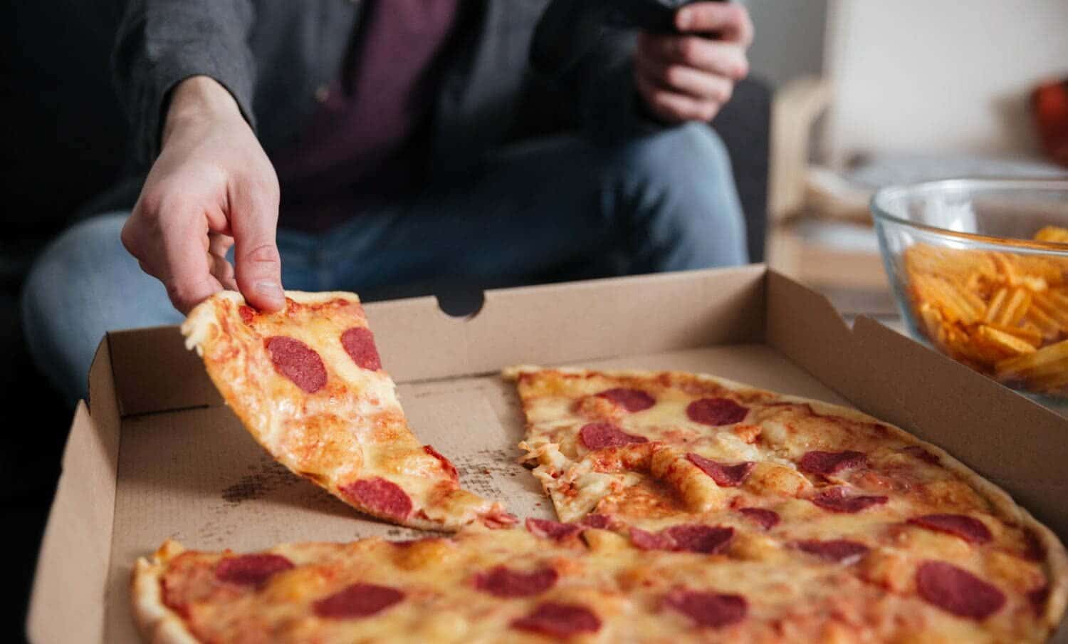 Joven jugador mientras se come / comer r&aacute;pido