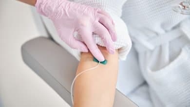 paciente femenina acostada en la cama con cat&eacute;ter en la vena / sueroterapia para la piel