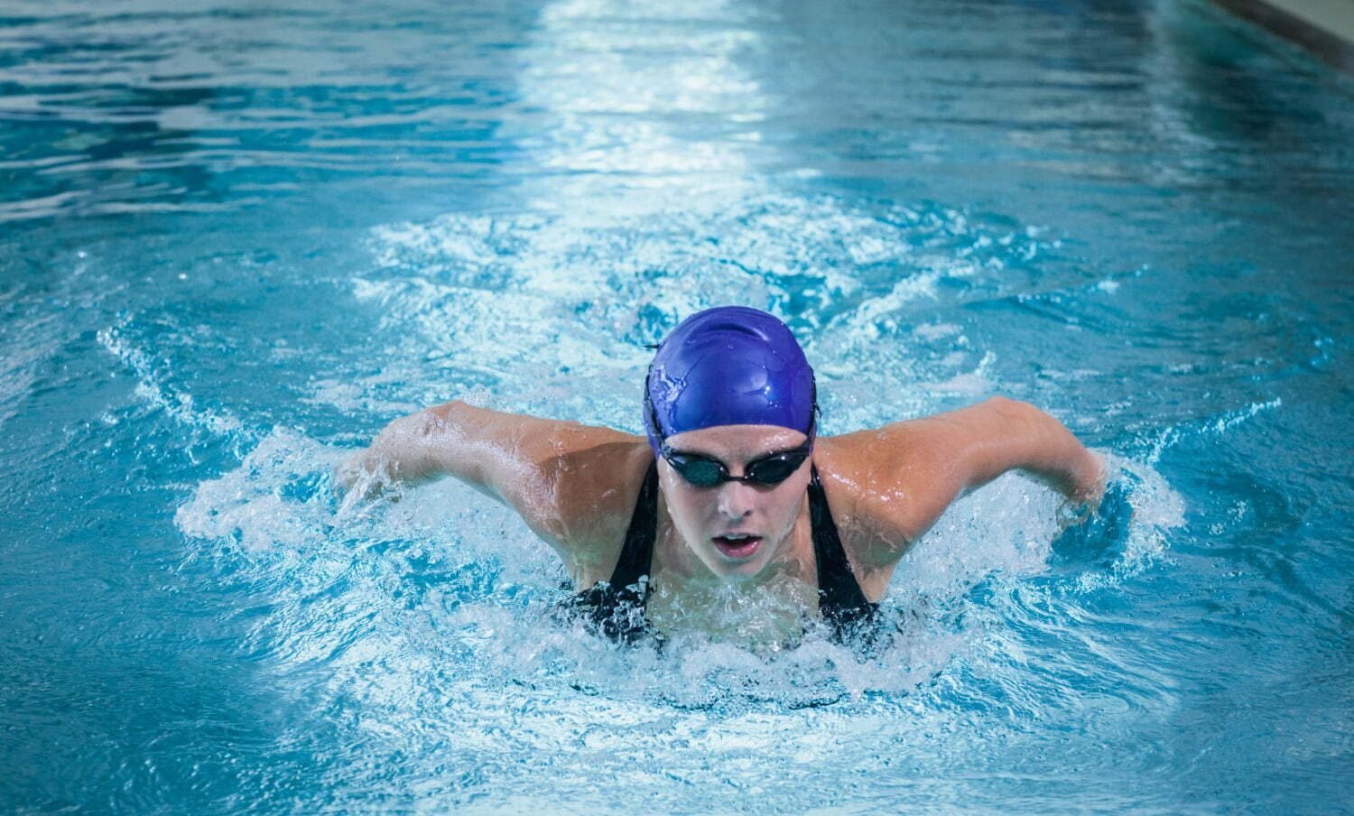 mujer practicando natación en una piscina / lesiones en las rodillas