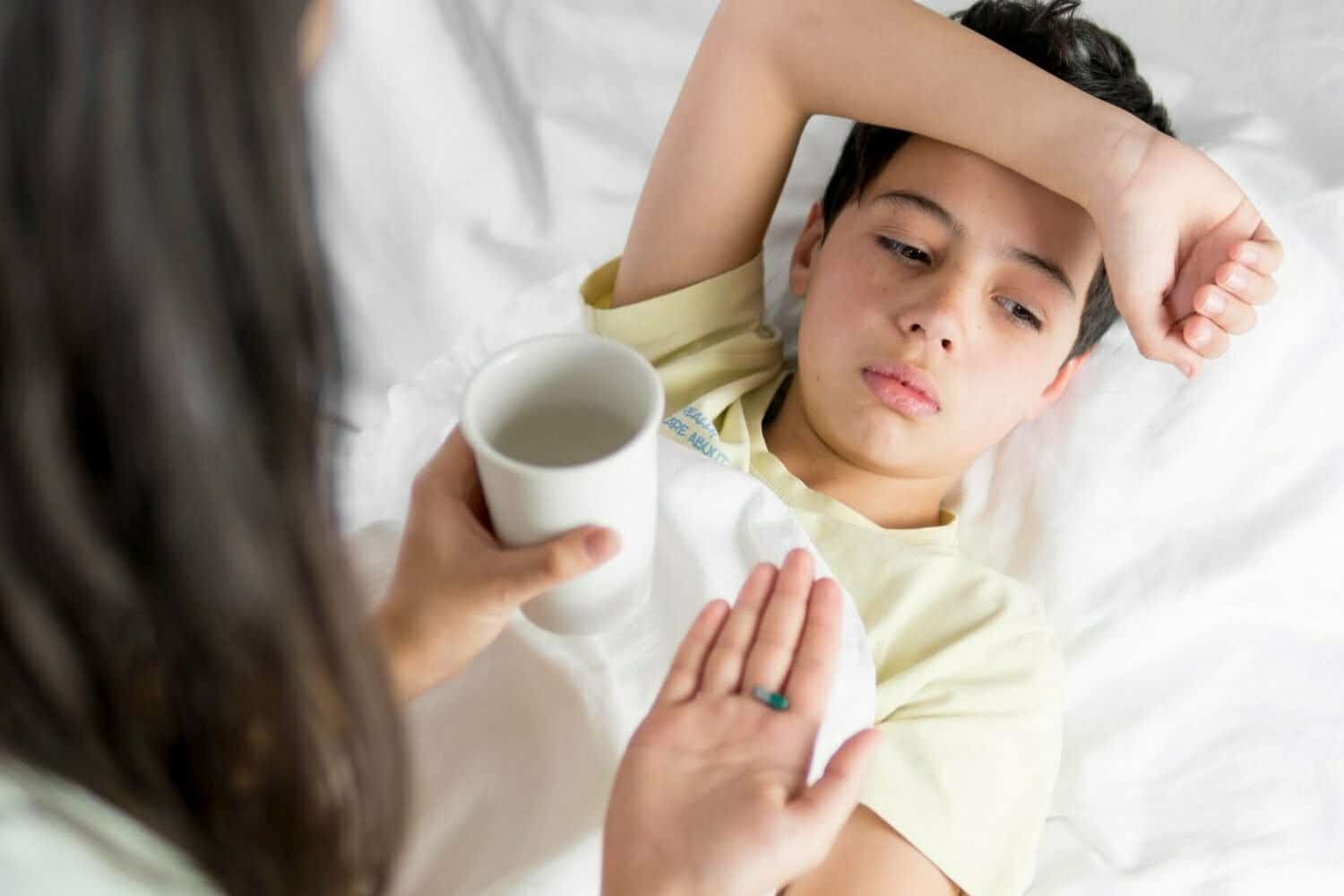 ni&ntilde;o enfermo tomando pastilla / gastritis