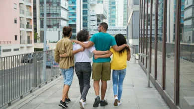 cuatro personas caminan abrazadas por un puente relaciones