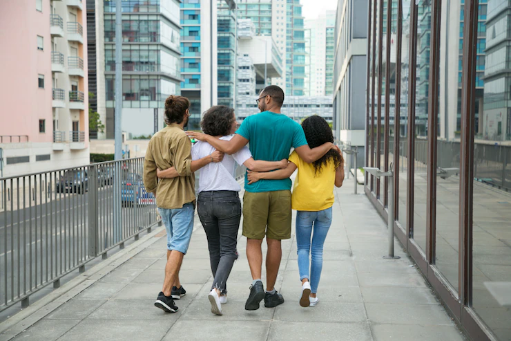 cuatro personas caminan abrazadas por un puente relaciones / feliz / final de la vida, amigos