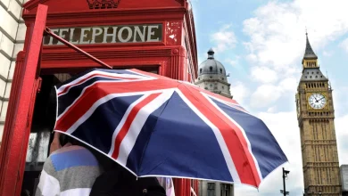 sombrilla con la bandera del reino unido junto a una caseta de teléfono público