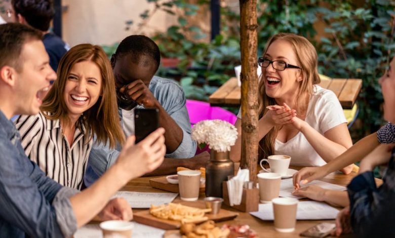 grupo de amigos comiendo en medio de risas / la risa