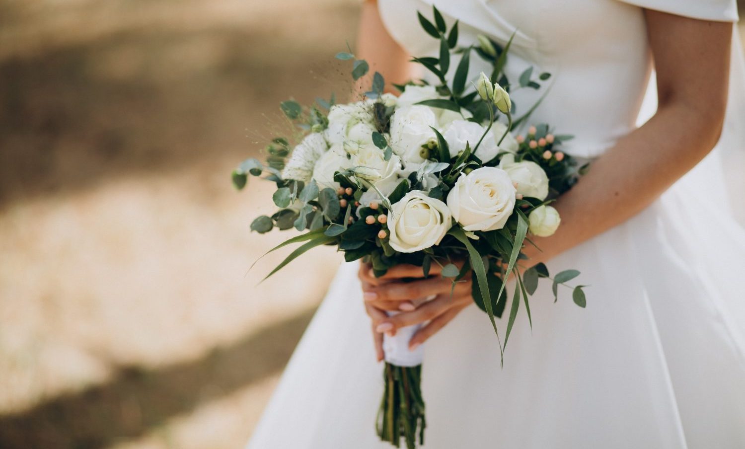 Mujer con vestido de boda y con floren en mano | boda expareja