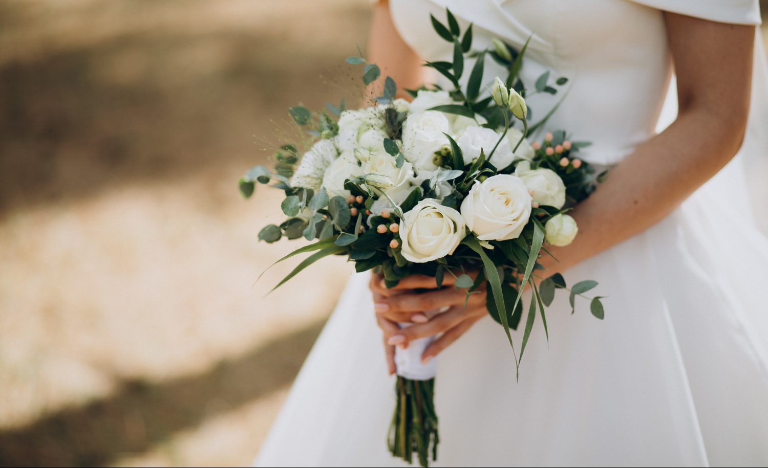 Mujer con vestido de boda y con floren en mano | boda expareja