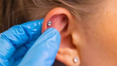 Profesional sosteniendo la joya de perforaci&oacute;n justo antes de enroscar la bola / perforaciones