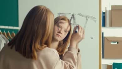 adolescente con cara de tristeza escribiendo en un espejo la palabra gorda en ingl&eacute;s - la relaci&oacute;n entre la nutrici&oacute;n y la salud mental