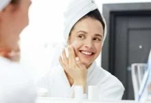 mujer aplicándose crema en su rostro para mantener la piel hidratada / cremas antiarrugas