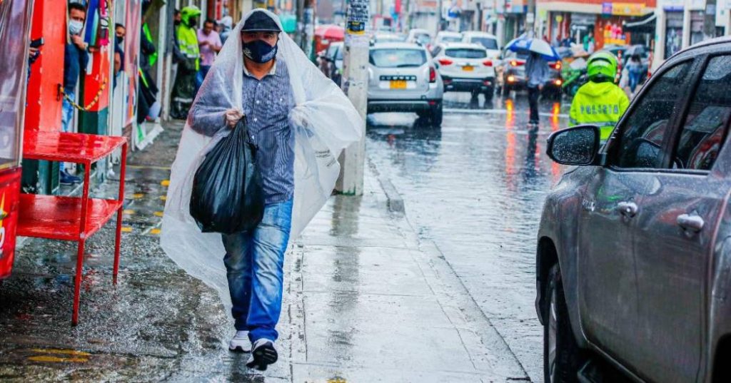 hombre caminando por la calle en medio de la lluvia / temporada de lluvias / ciclón / Ideam