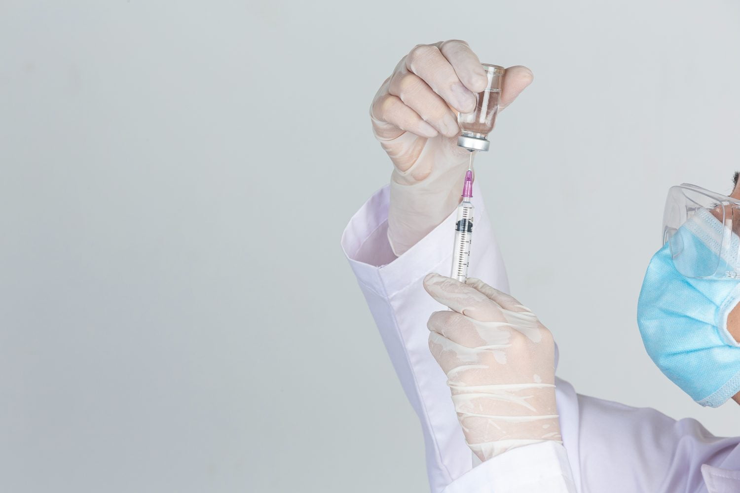joven doctor sostiene una jeringa / vacunas contra la viruela símica | vacuna viruela símica / vacuna contra el dengue / vacunas para COVID-19