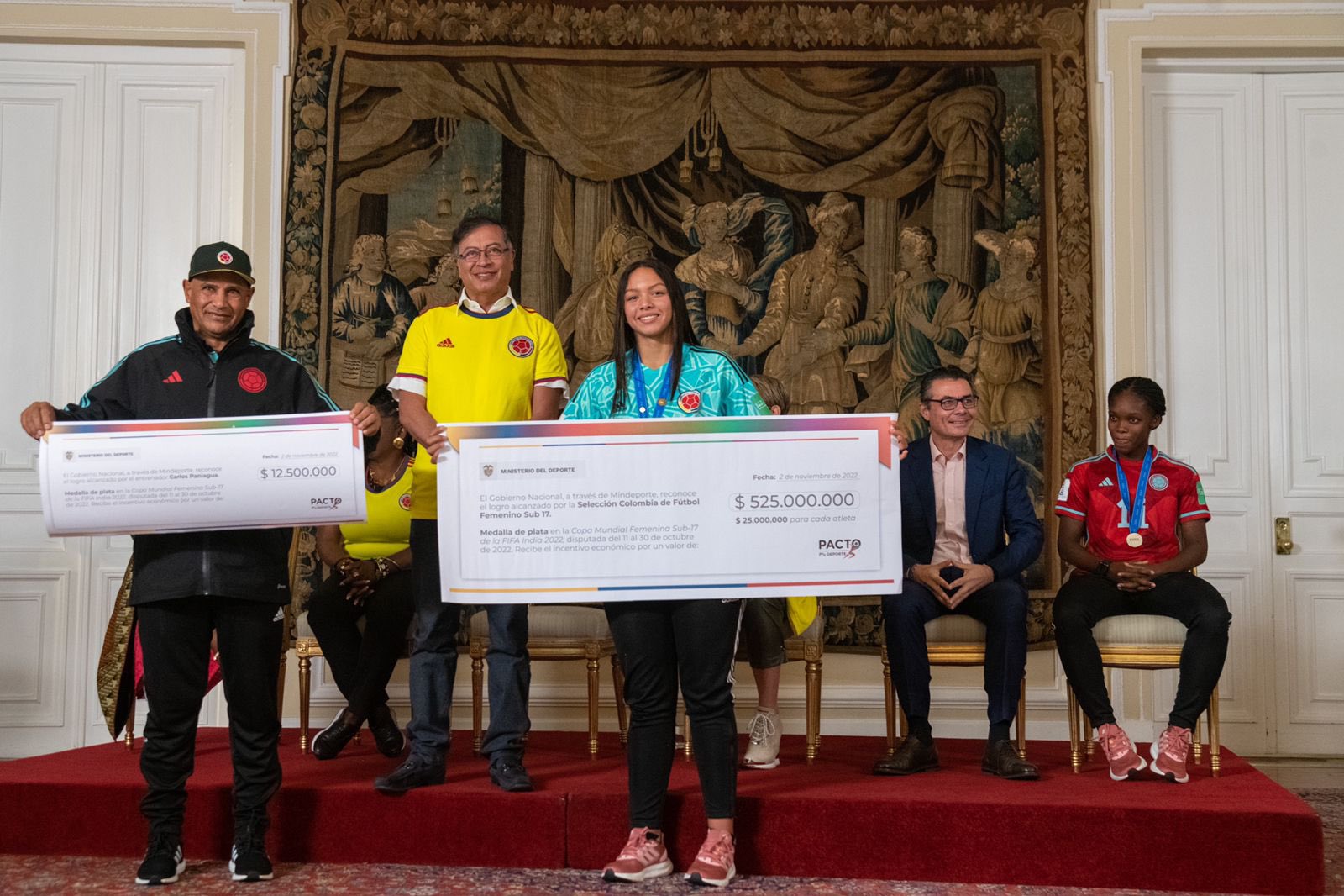 jugadora de la selecci&oacute;n colombia sostiene el cheque entregado por el Gobierno