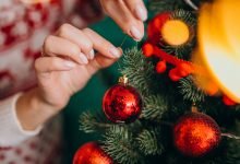 decorando el árbol de navidad con bolas rojas