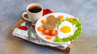 desayuno con huevos fritos y pan en forma de coraz&oacute;n y verduras frescas | alimentos que debes evitar en el desayuno