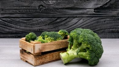 Racimos de brócoli en caja de madera cerca de todo el brócoli fresco