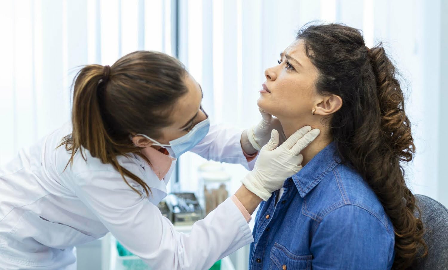 Endocrinólogo examinando la garganta de una mujer / cáncer de garganta