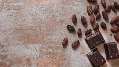 Piezas de chocolate con granos de cacao en bruto en el fondo r&uacute;stico - cacao y la hipertensi&oacute;n