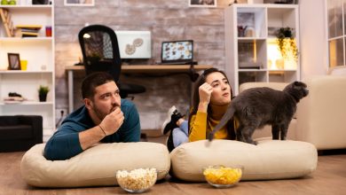 pareja en una relaci&oacute;n, sentados en el suelo y viendo la televisi&oacute;n en su sala de estar