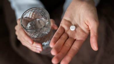 Cierra las manos sosteniendo la pastilla y el vaso / efecto placebo