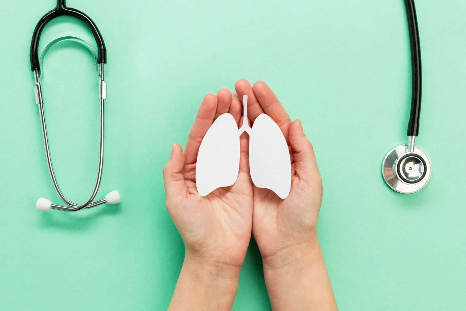 manos sosteniendo pulmones hechos de papel