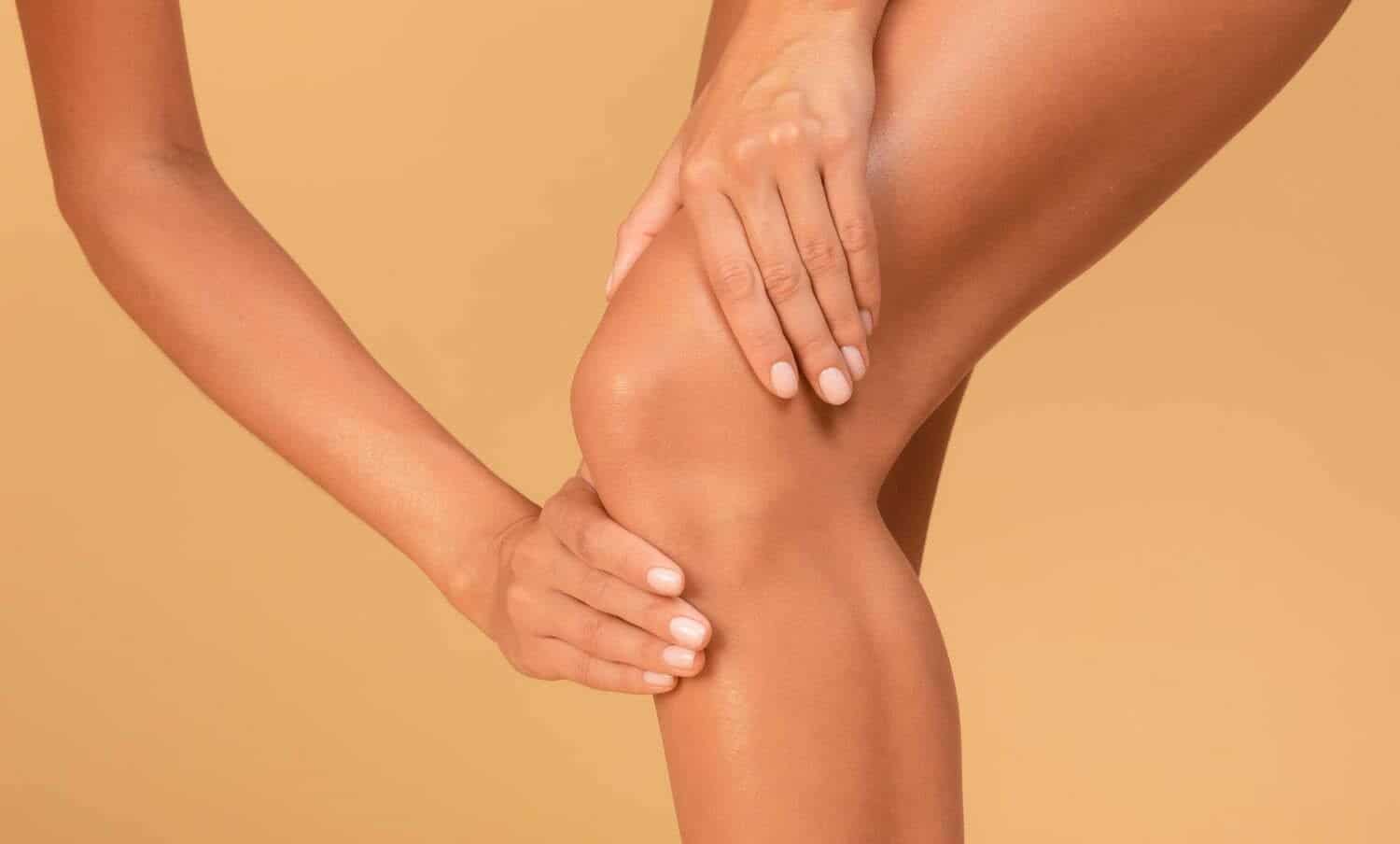 mujer masajea sus piernas que se inflaman