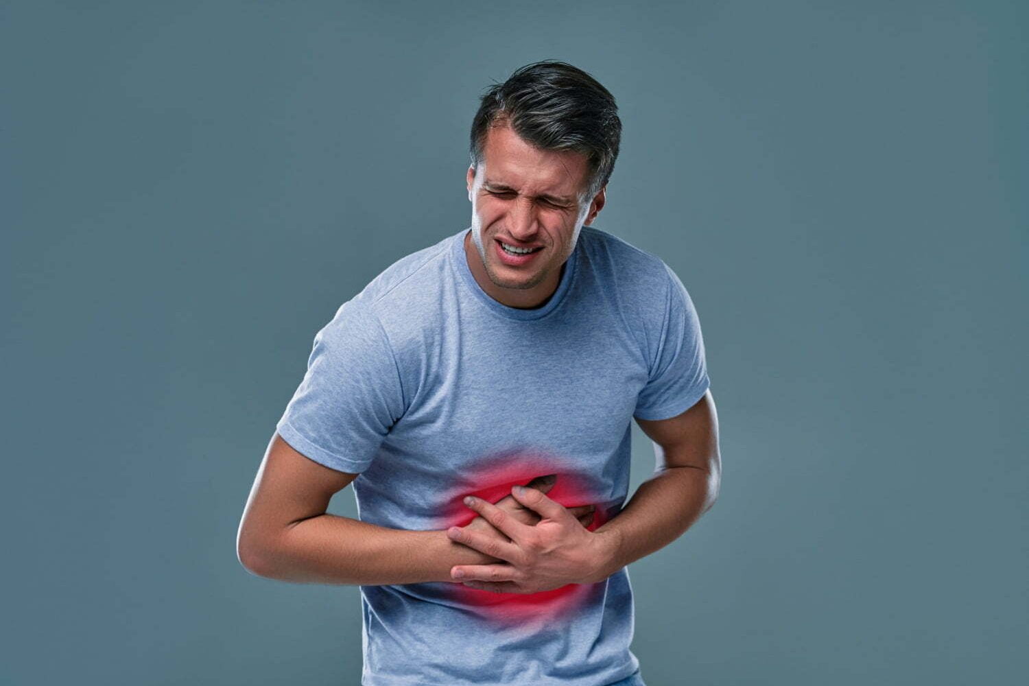 Hombre con dolor de estómago por grastritis relacionada con las emociones / parásitos