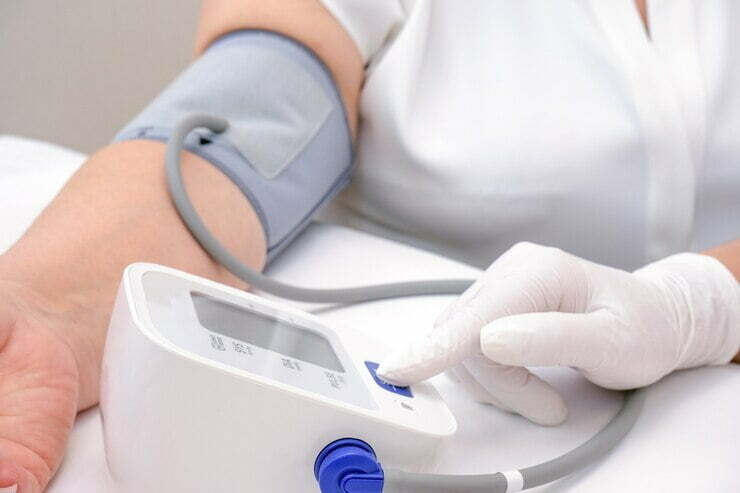 El médico mide la presión arterial de una persona adulta.