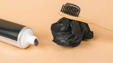 Un tubo de pasta de dientes con la adici&oacute;n de carb&oacute;n y un cepillo de dientes con pasta dental de carb&oacute;n activado