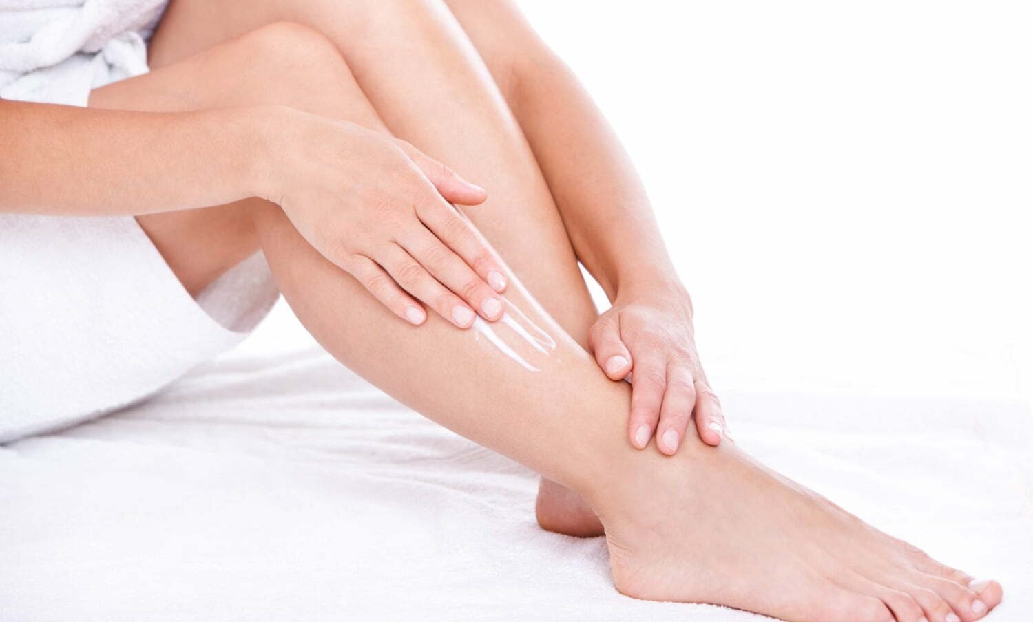mujer aplicando crema hidratante casera en sus piernas