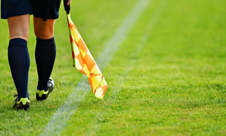 &Aacute;rbitro asistente se mueve a lo largo de la l&iacute;nea lateral durante un partido de f&uacute;tbol / Mary Blanco