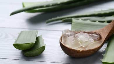 trozos de aloe vera para eliminar el acne, sobre cuchara de madera hojas de la planta.