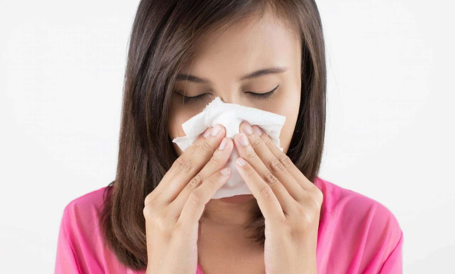 mujer soplando su nariz por congesti&oacute;n nasal