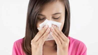 mujer soplando su nariz por congesti&oacute;n nasal