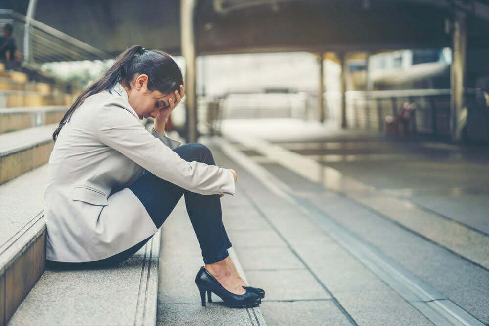 Mujer empresaria estresada en el trabajo mientras se sienta al aire libre en las escaleras / estrés laboral / agotamiento emocional / rumia mental / alzheimer