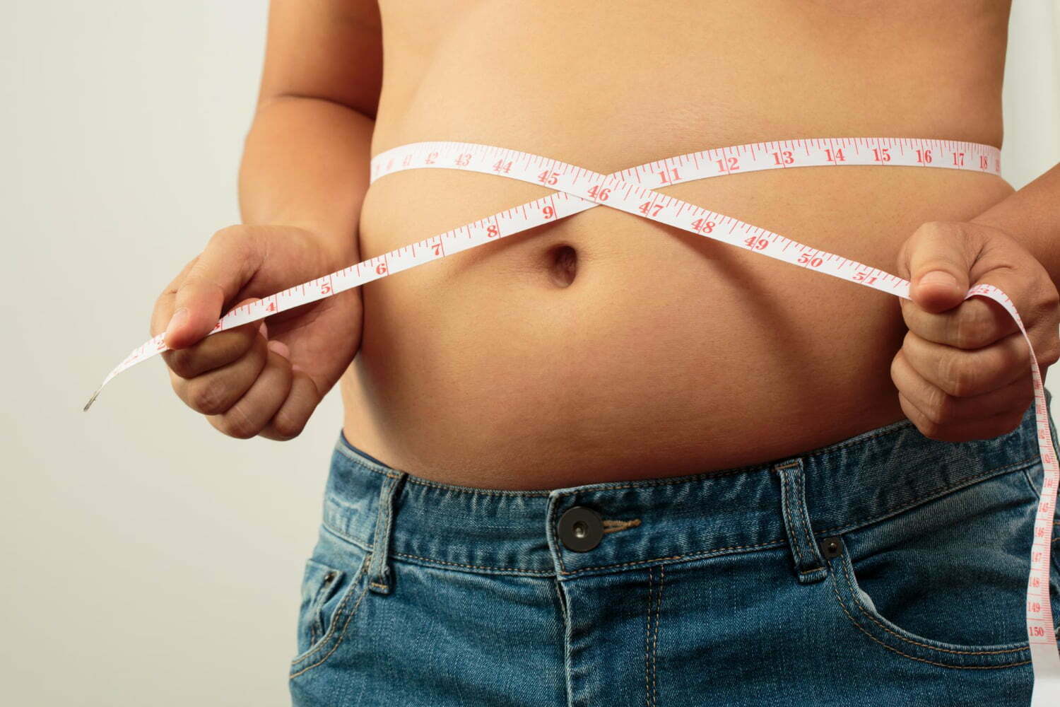 Hombre midiendo su cintura para sacar su índice de masa corporal