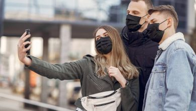 tres personas con tapabocas haci&eacute;ndose un selfie en la calle