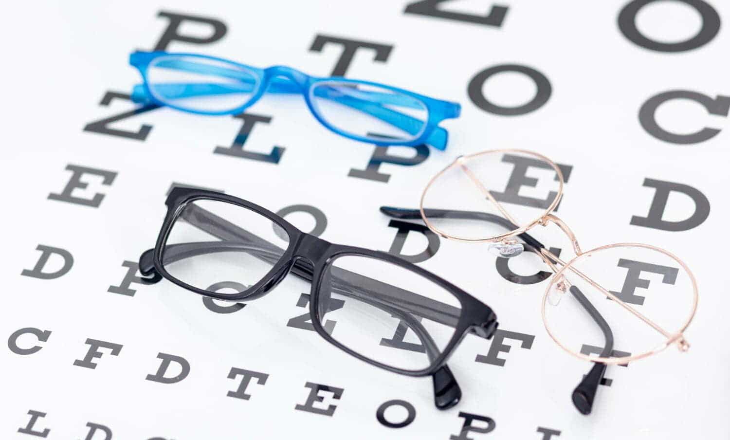 varios estilos de gafas sobre tabla de Snellen