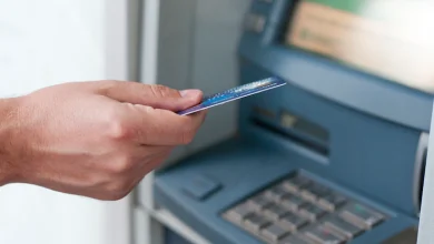 mano que inserta la tarjeta del cajero automático en la máquina de banco para retirar - Los bancos que más cobran por el uso de tarjeta débito y retiro en cajeros en fin de año