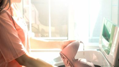 Mujer sosteniendo un sost&eacute;n limpio mientras lava la ropa en casa / ropa interior