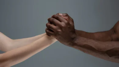 manos blancas entrelazadas con manos negras, símbolo contra el racismo