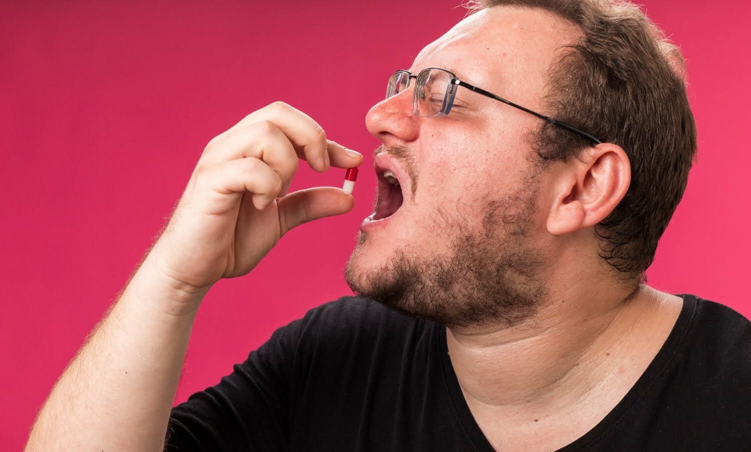 hombre obeso de mediana edad, tomando quemadores de grasa en forma de p&iacute;ldora.