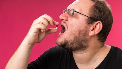 hombre obeso de mediana edad, tomando quemadores de grasa en forma de p&iacute;ldora.