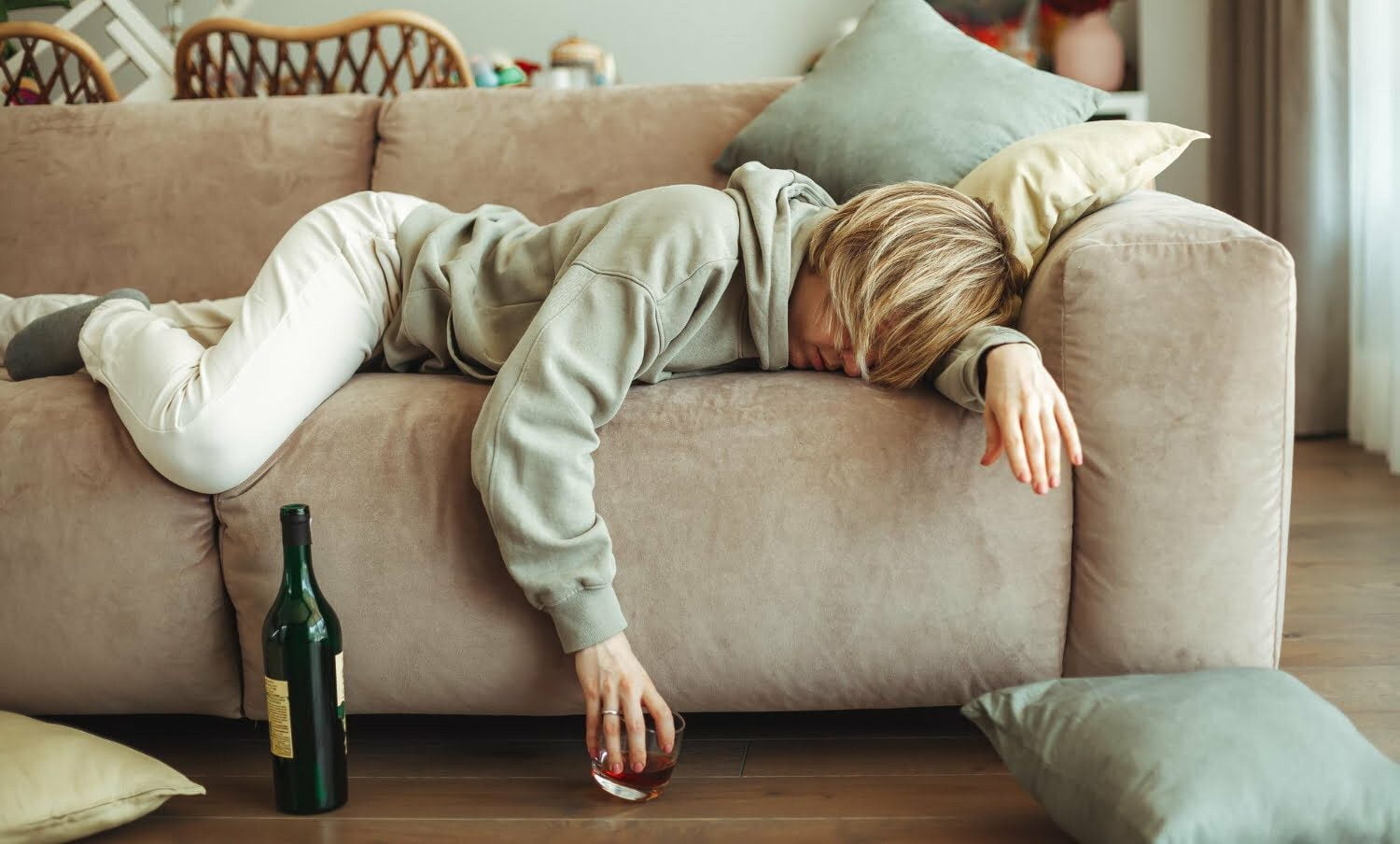 mujer con guayabo, acostada en un mueble, luego de tomar whiskey